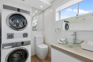 een wasruimte met een wasmachine en droger en een wastafel bij Wantima Hastings St 1 Bedroom Unit in Noosa Heads