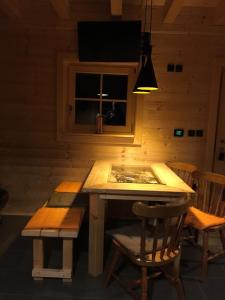 drewniany stół i krzesła w pokoju z oknem w obiekcie Loghouse Brunka - Escape from life on a highway w mieście Gornja Radgona