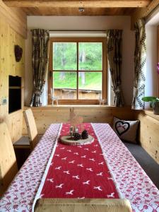 a dining room with a table with a red blanket on it at Ciasa Coletin in Alvera