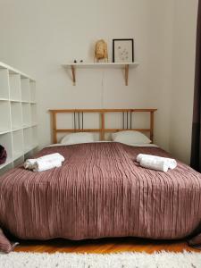 ein Schlafzimmer mit einem großen Bett mit zwei Handtüchern darauf in der Unterkunft CityCenter Apartment TTO in Győr