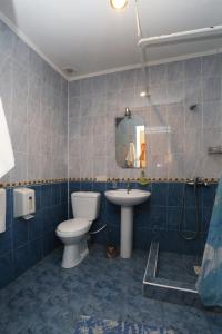 Baño de azulejos azules con aseo y lavamanos en Santa-Fe Hotel, en Koktebel