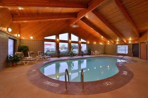 a large indoor swimming pool in a building with wooden ceilings at Super 8 by Wyndham Glenwood in Glenwood