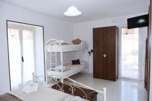 ein weißes Schlafzimmer mit einem Etagenbett und einem Spiegel in der Unterkunft Casa Santa Rita / Locazione turistica Sicilia / Santa Domenica Vittoria in Santa Domenica Vittoria