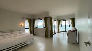 1 dormitorio con cama y ventana grande en Cozy Khanom โคซี่ ขนอม en Ban Na Dan