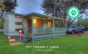 
a little girl standing in front of a house at Beechworth Lake Sambell Caravan Park in Beechworth
