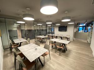 a dining room with tables and chairs and lights at Lake Hotel Benaco in Nago-Torbole