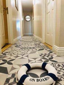 a hallway with a white and black floor with a life raft on the floor at The Waterside Apartment 112 Harbour Mills in Westport