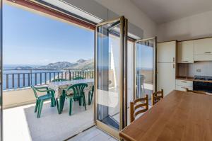 a kitchen and dining room with a view of the ocean at CASA VACANZE ANDREANA in Letojanni