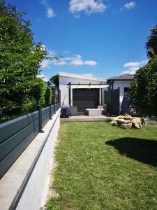 un patio trasero con una pared de retención y césped en Maison du Moulin, en Yvrac