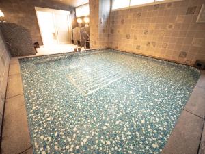 a swimming pool with a tile floor in a bathroom at Hotel Front Inn Fukuoka Airport in Fukuoka