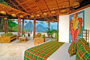 a bedroom with a bed and a painting of a woman on the wall at Anse Chastanet Resort in Soufrière