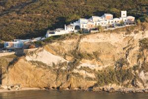 a group of houses on a cliff next to the water at Hotel Chiaia Di Luna in Ponza