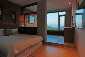 Uma cama ou camas num quarto em Jiufen HappyLand B&B
