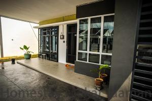 homestay mekar idaman في كيبالا باتاس: شرفة منزل بها نباتات الفخار