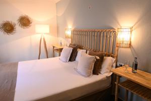 a bedroom with a bed with white sheets and pillows at Stadthotel Santanyi in Santanyi