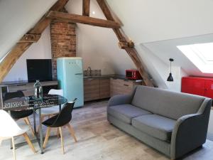 a living room with a couch and a table at Au cochon qui rit in Flines-lès-Mortagne