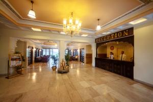 un gran vestíbulo con una lámpara de araña y una tienda en Hotel Hilltop Palace, en Udaipur