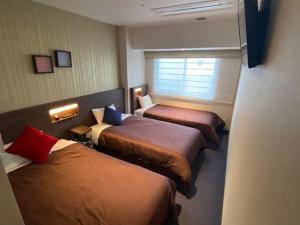 
a bed room with two beds and two windows at Hotel Bay Gulls in Tajiri
