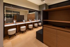 un bar con una fila de sillas blancas en una habitación en Hotel Bay Gulls, en Tajiri