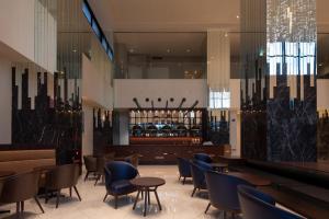 Un restaurante con sillas y mesas y un bar. en Hotel Bay Gulls, en Tajiri