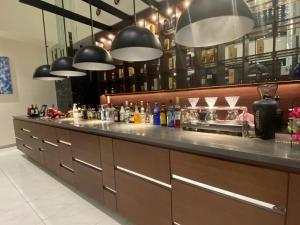 a bar with a long counter with lights above it at Hotel Bay Gulls in Tajiri