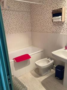 une salle de bain avec une baignoire, des toilettes et un lavabo dans l'établissement La Vieille Crêperie de Mangouëro, à Cléguérec