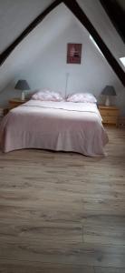 une chambre avec un grand lit dans un grenier dans l'établissement La Vieille Crêperie de Mangouëro, à Cléguérec