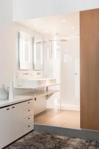 a white bathroom with two sinks and a shower at Hotel C2 in Marseille
