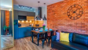 a dining room and kitchen with a brick wall at Apartamenty Holiday Mountain Residence by Royal Aparts in Świeradów-Zdrój
