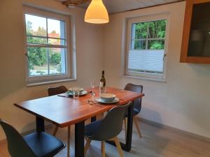 a dining room table with chairs and a bottle of wine at Apartment Happy Memories in Titisee-Neustadt