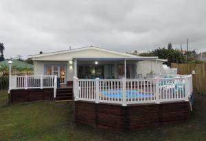a small house with a porch and a pool at Seagulls Beach House in Port Shepstone