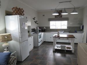 a kitchen with a refrigerator and a table in it at Seagulls Beach House in Port Shepstone