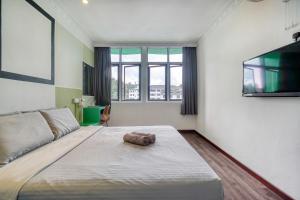 a bedroom with a large bed and a flat screen tv at Parkland Express in Brinchang
