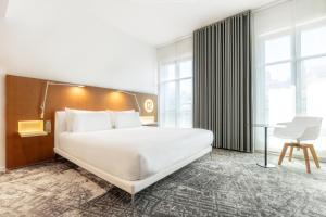 a bedroom with a large white bed and a desk at Hotel C2 in Marseille