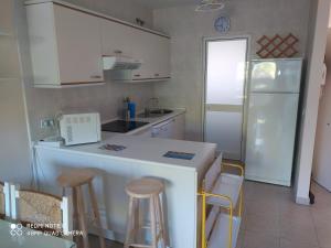 cocina con armarios blancos y nevera blanca en Edificio Santana II, en Isla Cristina