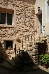 a stone building with a stone staircase in front of a building at Le Bastidon de Louis, L'Isle sur la Sorgue in LʼIsle-sur-la-Sorgue
