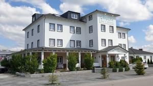 - un grand bâtiment blanc avec un panneau dans l'établissement Hotel Echinger Hof, à Eching