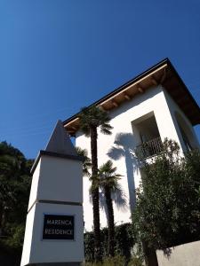 un edificio bianco con palme di fronte di Marenca Residence a Cannobio