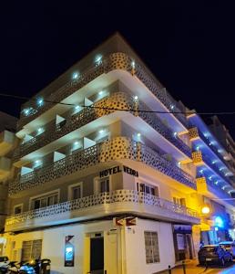 - un grand bâtiment avec balcon la nuit dans l'établissement Hotel Vedra, à Sant Antoni de Portmany