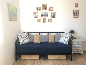 eine blaue Couch in einem Zimmer mit Bildern an der Wand in der Unterkunft Tranquille au PANIER face à la mer in Marseille