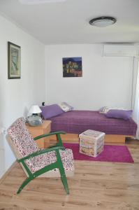 - une chambre avec un lit, une chaise verte et une table dans l'établissement Apartment Marioni, à Buzet