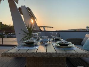 una mesa con platos y copas de vino en el balcón en Sirena Floating House Portorož, en Portorož