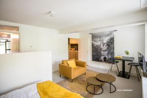 a living room with a bed and a table and a chair at Bed&Breakfast Tussen de Poorten in Kampen