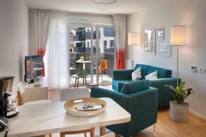 uma sala de estar com um sofá azul e uma mesa em Domitys - Galilée em Cergy