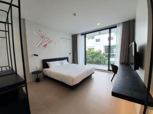 um quarto com uma cama e uma grande janela em CHERN Bangkok em Bangkok