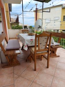 een tafel en stoelen op een patio met een parasol bij Apartman Gabriel in Podgora