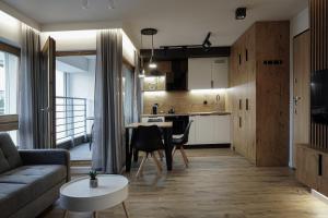 ein Wohnzimmer und eine Küche mit einem Sofa und einem Tisch in der Unterkunft Awanport B21 in Gdynia