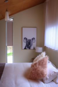a bedroom with a picture of a dog on the wall at Ulverstone River Retreat in Ulverstone