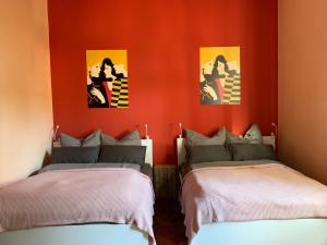 2 łóżka w pokoju z czerwonymi ścianami w obiekcie Villa 25 w mieście Gartz an der Oder