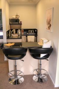 a kitchen with a counter and two bar stools at Ulverstone River Retreat in Ulverstone